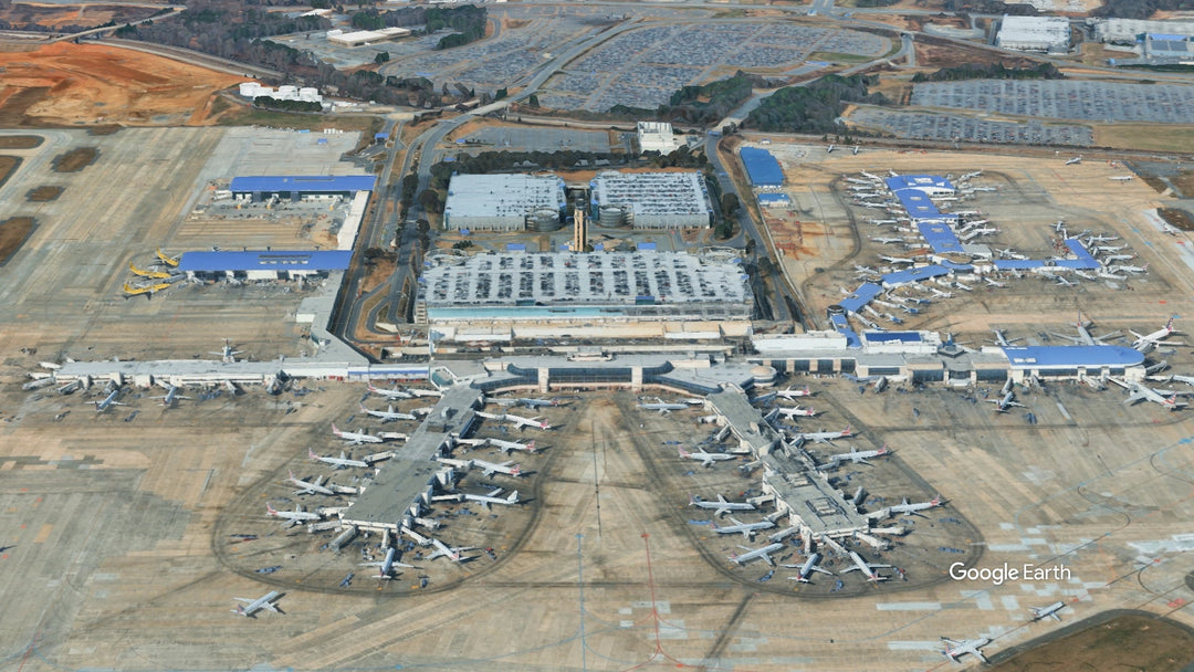 Aerial view of Charlotte Douglas International Airport (CLT) in Charlotte, North Carolina, showing the terminal, concourses, gates, and aircraft parked on the apron.