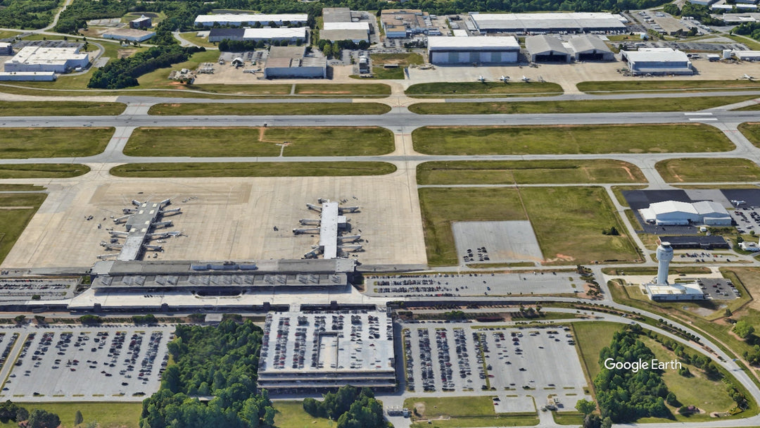 Aerial view of Piedmont Triad International Airport GSO in Greensboro, North Carolina, showing the terminal, concourses, runways, control tower, and surrounding aerospace campus.