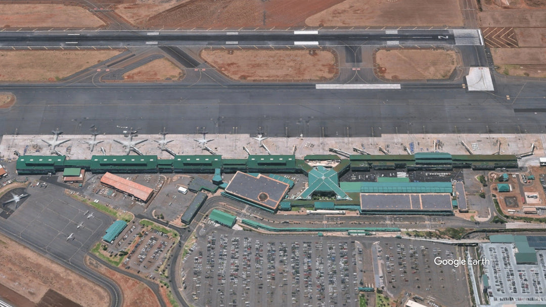 Aerial view of Kahului Airport (OGG) in Maui, Hawaii, showing the passenger terminal, gates, aircraft, taxiways, and runway.