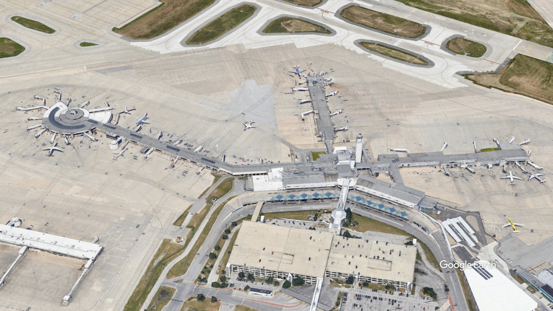 Aerial view of Cleveland Hopkins International Airport (CLE) in Cleveland, Ohio, showing the terminal, concourses, gates, parked aircraft, and airport ramp areas.
