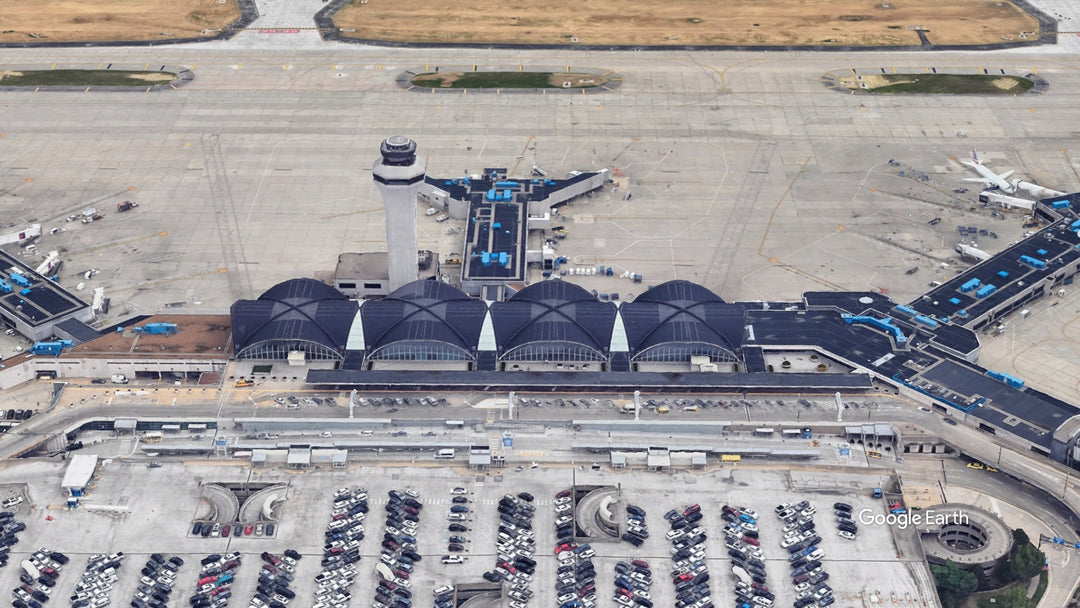 Aerial view of St. Louis Lambert International Airport showing the iconic terminal, control tower, concourses, aircraft gates, and ramp area at STL Airport in Missouri.