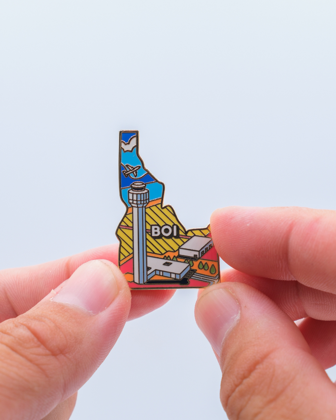BOI airport pin for Boise Air Terminal / Gowen Field, held by hand.