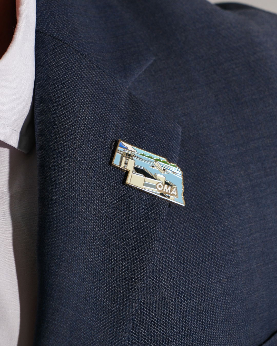 OMA airport pin for Eppley Airfield, worn on a blue jacket lapel.