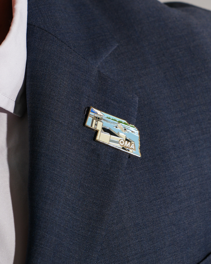 OMA airport pin for Eppley Airfield, worn on a blue jacket lapel.